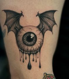 a tattoo with an evil eye and bat wings