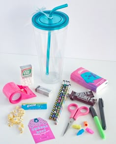 the contents of a plastic cup are arranged on a white surface with scissors, pencils, markers and other items