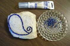 a glass plate with a beaded necklace on it next to a rock and tube of toothpaste