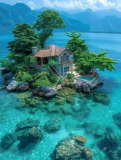 an island with a house on it in the middle of the ocean, surrounded by rocks and trees