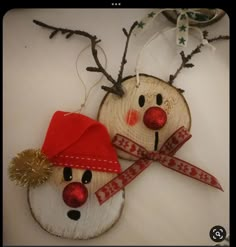 two snowmen made out of wood are hanging on the wall