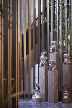 several statues in the middle of a building with bamboo trees growing out of it's sides