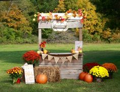 a wooden stand with hay bales and pumpkins