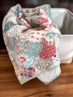 a close up of a cloth covered object on a wooden table next to a container