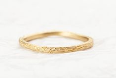 a gold wedding band with leaves on it