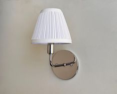 a wall light with a white shade on it