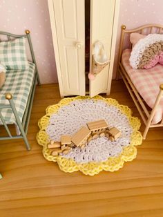 a doll's bedroom with two beds and a toy house in the corner on the floor