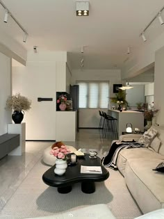 a living room filled with furniture next to a kitchen