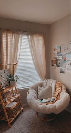 a living room with a chair, window and pictures on the wall in it's corner