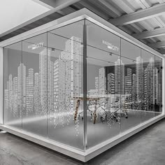 a glass display case with cityscape in the background and an office desk on one side