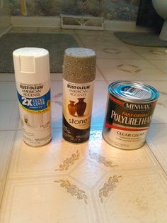 three different types of paint sitting on top of a white tile floor next to each other