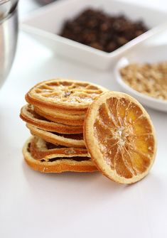 a stack of orange slices sitting on top of a white table next to bowls of cereal