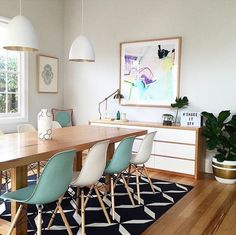 a dining room table with chairs and a rug on the floor in front of it