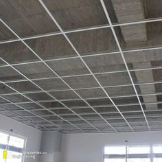 an unfinished ceiling in a room with two windows