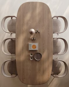 an overhead view of a wooden table with chairs and other items on it, in front of a white wall