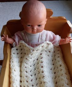 a baby doll in a crocheted blanket