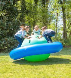 three children playing on an inflatable slide