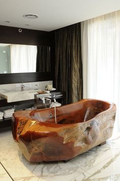 a large wooden bathtub sitting on top of a bathroom floor