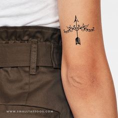 a tattoo on the arm of a person with an arrow in it's center