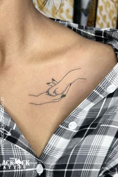 a woman with a tattoo on her chest holding a small bird in her right hand