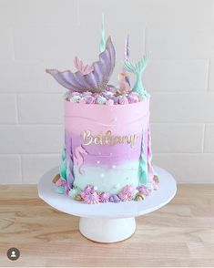 a birthday cake decorated with pink, purple and green frosting