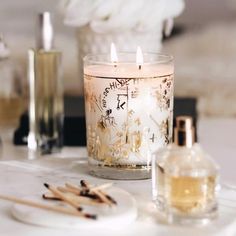 a candle sitting on top of a table next to some bottles