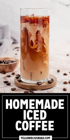 homemade iced coffee in a tall glass with ice and cinnamon on the rim, surrounded by coffee beans