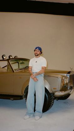 a man standing in front of an old car