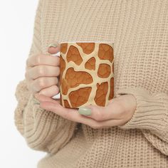 a woman holding a coffee mug with giraffe print on it's side