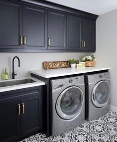 a washer and dryer in a room with black cabinets