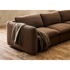 a brown couch sitting on top of a wooden floor