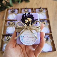 a hand holding a small purple box with flowers on it