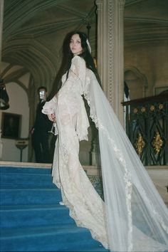 a woman in a wedding dress standing on some stairs