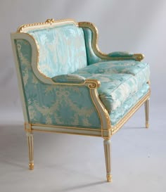 an ornately decorated chair with gold trimmings and blue upholstered fabric