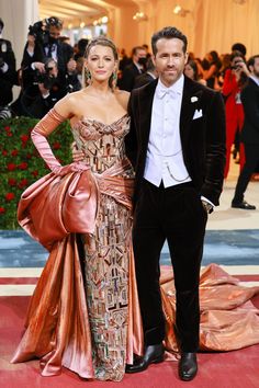 a man and woman standing next to each other on a red carpet at an event