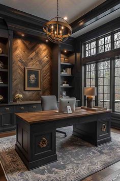 an office with black walls and wooden floors, built in shelving units, large windows, chandelier hanging from the ceiling