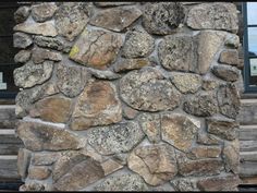 an old stone wall is shown in front of a window