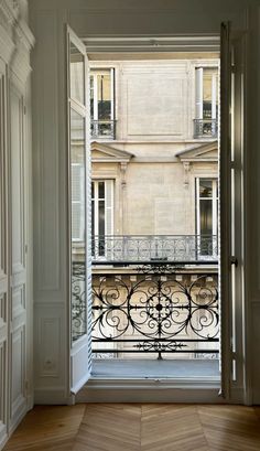 an open door leading to a balcony with wrought iron railings and balconies