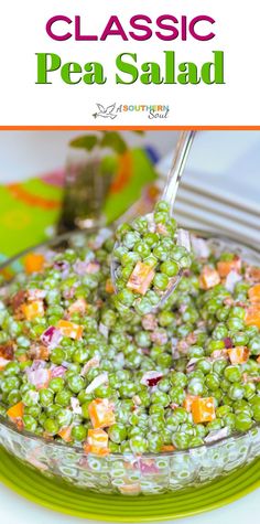 a bowl filled with peas and carrots on top of a green plate