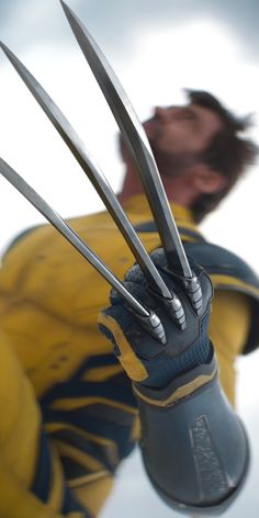 a man in yellow shirt holding up two large claws