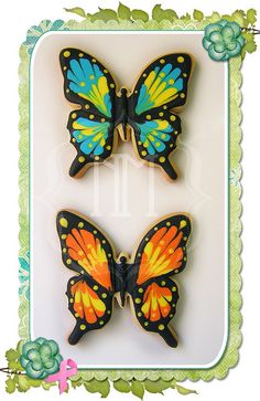 two decorated cookies in the shape of butterflies