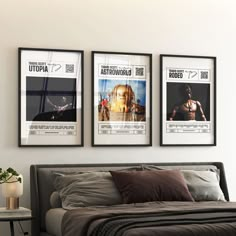 three movie posters hang on the wall above a bed in a room with white walls