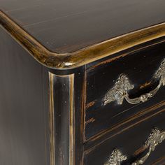 an antique black and gold chest of drawers