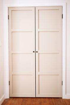 two white doors are open in an empty room