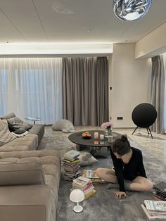 a woman sitting on the floor in front of a living room