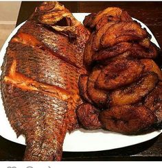 there is a white plate with some fish and other foods on it, along with the caption