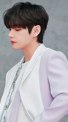 a man with black hair wearing a white jacket