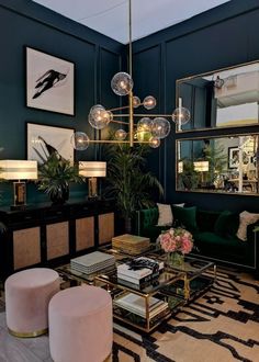 a living room filled with green furniture and lots of mirrors on the wall above it