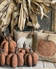 some pumpkins are sitting on a table next to pillows and corn stalks in the background