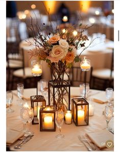 a centerpiece with candles and flowers on a table